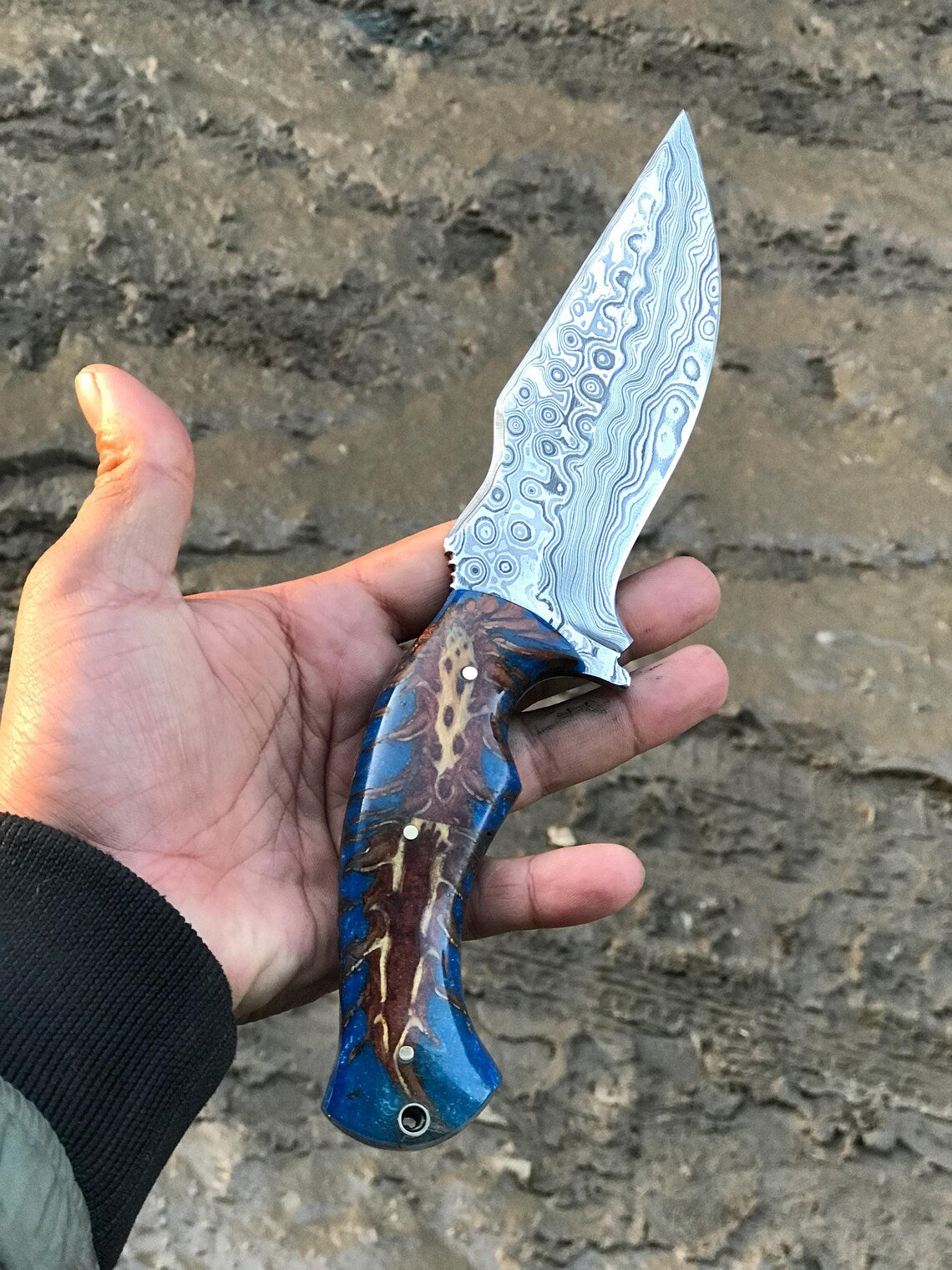 Pine-cone epoxy resin handle on a Damascus hunting knife