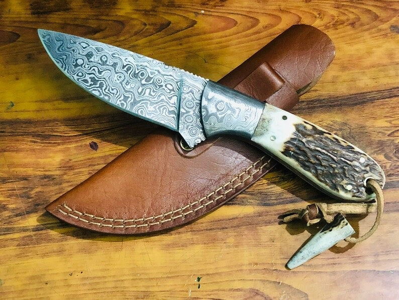 Deer skinning knife with Raindrops Damascus steel blade and antler horn handle.