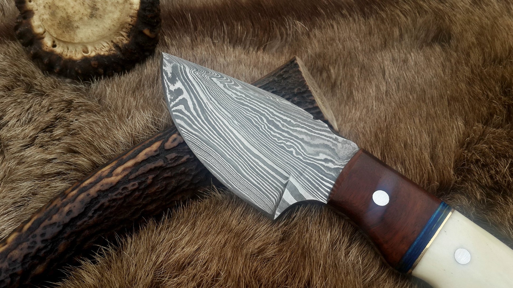 Close-up of the 3-inch Damascus steel blade showcasing its intricate patterns.