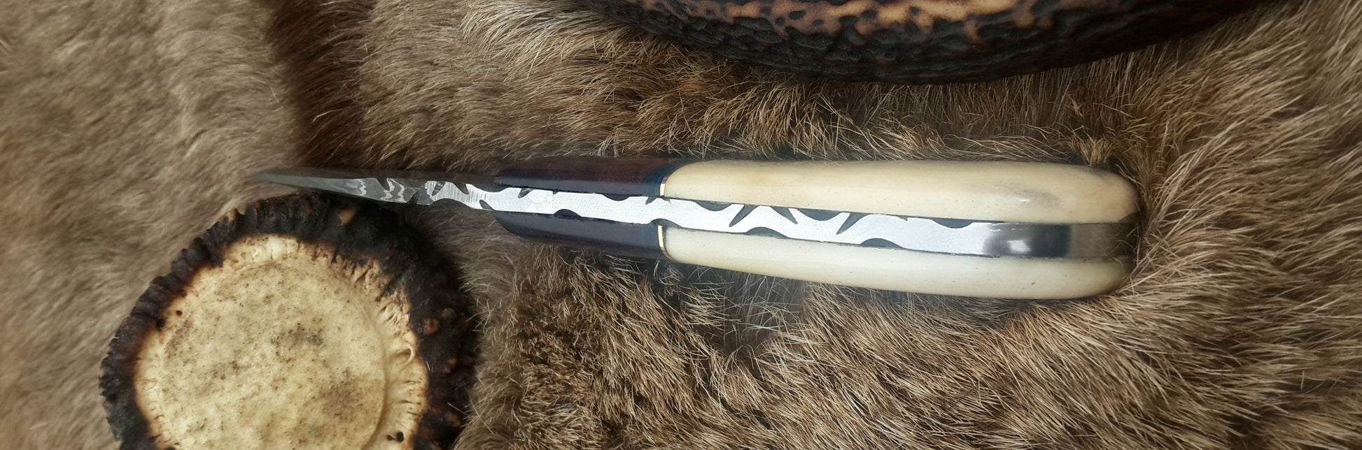 Bone and rosewood handle of the skinning knife, emphasizing comfort and grip.