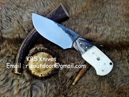 Custom 8-inch skinning knife with hand-forged 1095 steel blade and buffalo horn, camel bone handle.