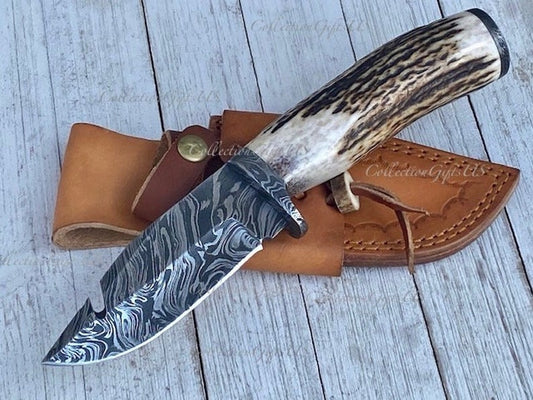 Deer skinning guthook knife with full tang Damascus steel blade and stag horn handle.