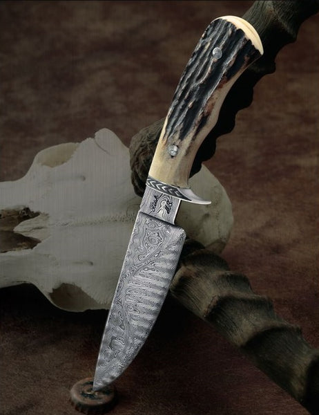 The Huntsman's Masterpiece: Full Tang Damascus Steel Hunting Knife with Antler Horn Handle – A precision-crafted hunting knife with a Damascus steel blade, antler horn handle, hand-engraved steel guard, leather sheath, and an overall length of 9 inches, available at KBS Knives Store.
