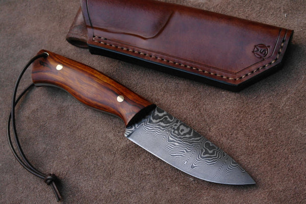 The Wilderness Trailblazer - An 8.5-inch hunting knife with a Full Tang Damascus Steel Blade and Rosewood handle, complete with a leather sheath, available at KBS Knives Store for outdoor enthusiasts and hunters.
