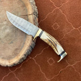 Close-up of antler horn handle and brass guards on Damascus knife
