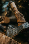 Battle axe with engraved 1095 steel blade and ash wood handle wrapped in leather
