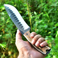 Close-up of hand-forged 1095 high carbon steel blade pattern on camping knife
