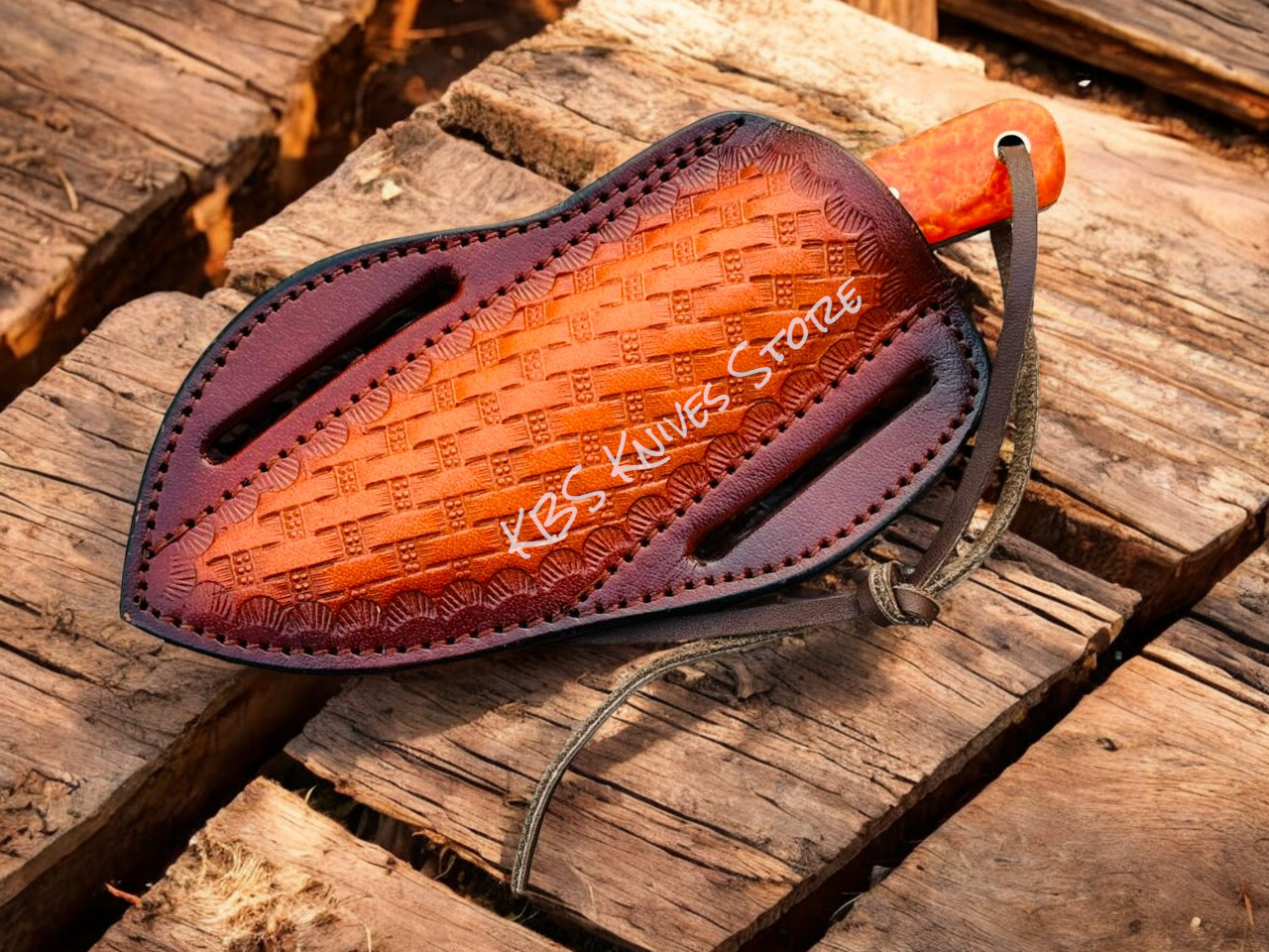 Leather knife sheath with 'KBS Knives Store' branding on a wooden surface