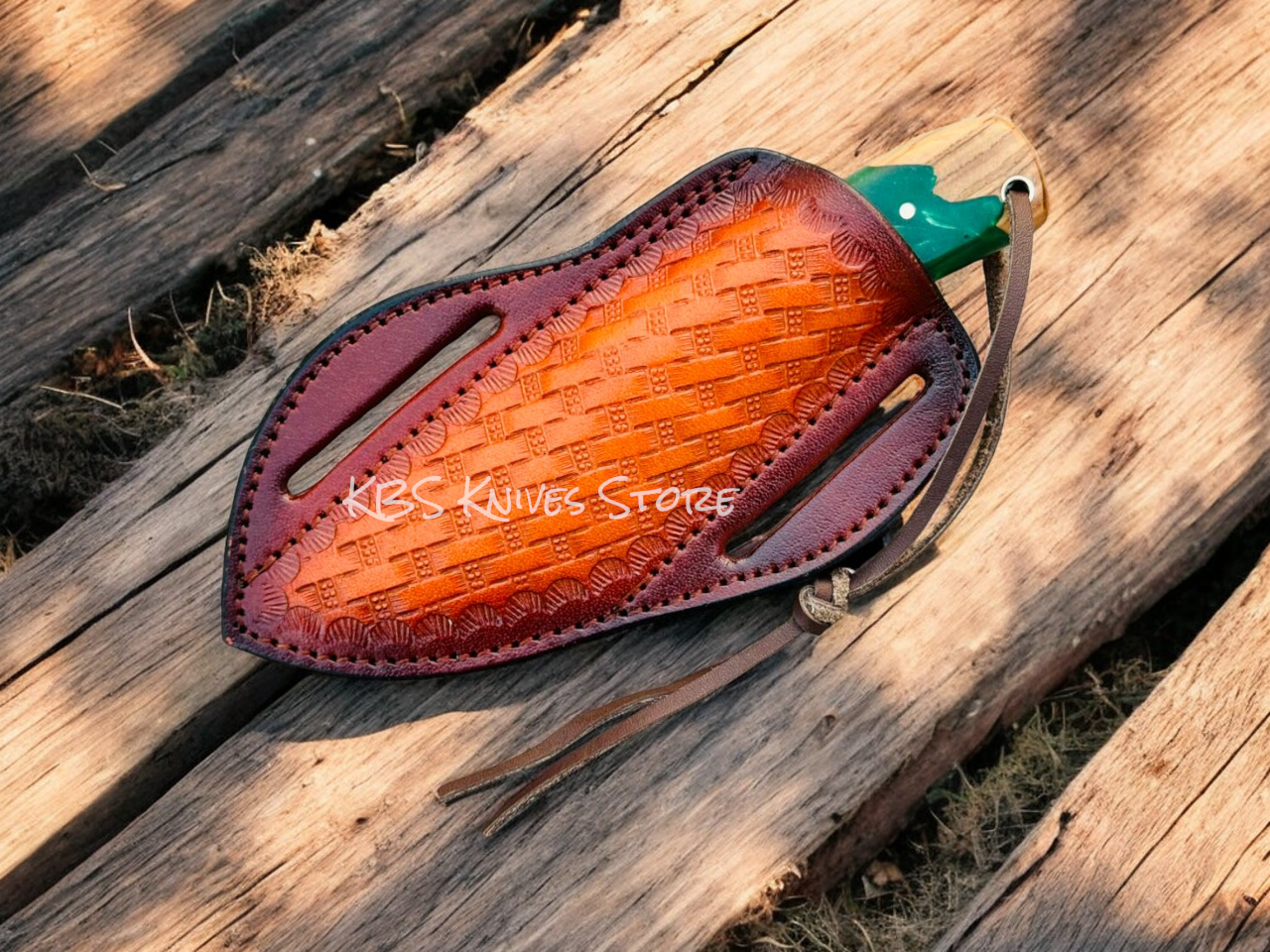 Leather knife sheath with embossed design on a wooden surface, featuring 'KBS Knives Store' branding.