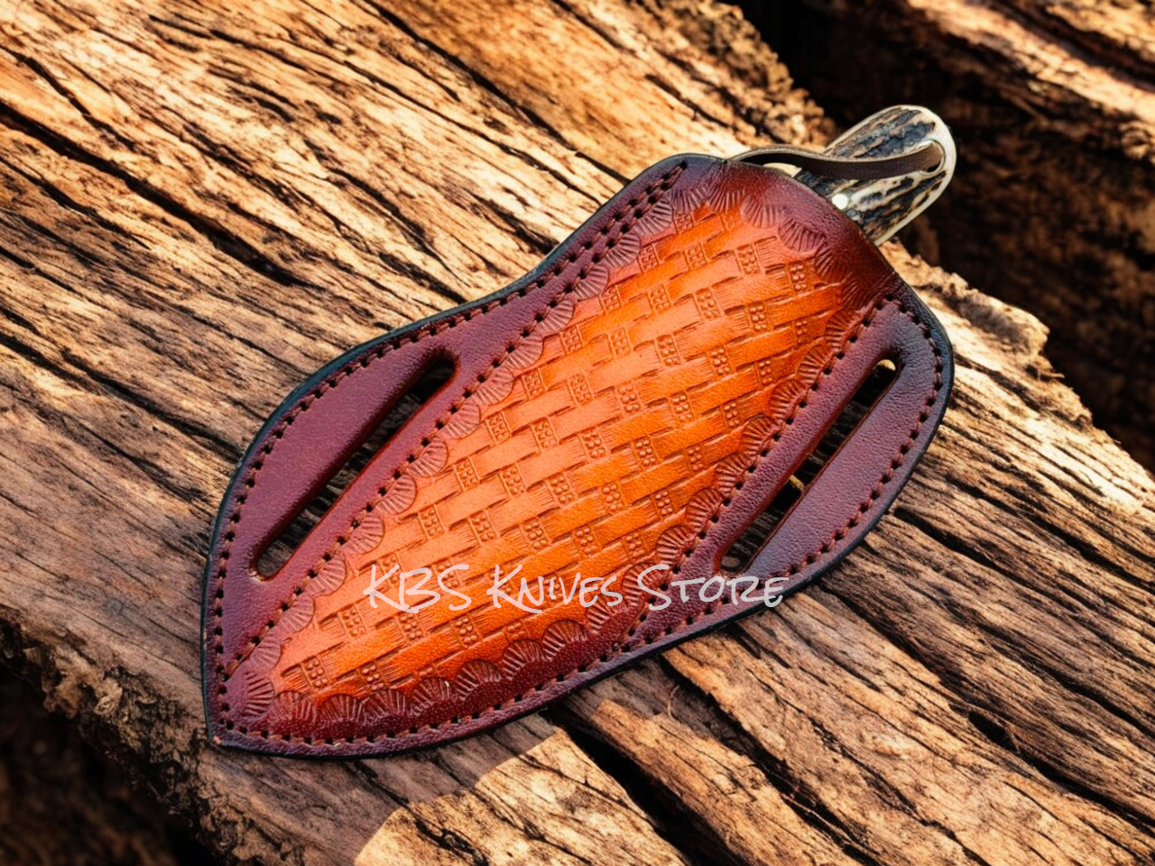 Leather knife sheath with embossed design on a wooden surface, branded 'KBS Knives Store'.