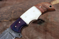 Close-up of G10, bone, and rosewood handle on Damascus steel knife
