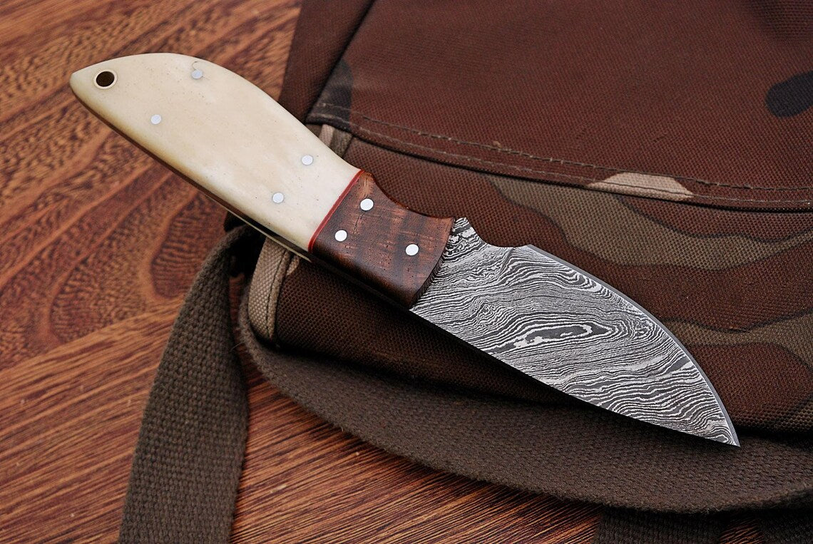 Great skinning knife with custom Damascus steel blade and rosewood and bone handle, Rockwell Hardness 55-58 HRC.
