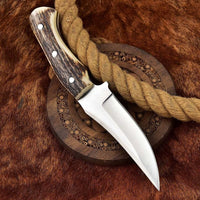 Deer skinning knife featuring full tang D2 steel construction and antler horn handle.
