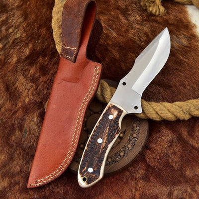 Custom handmade D2 steel skinning knife with antler horn handle and leather sheath.
