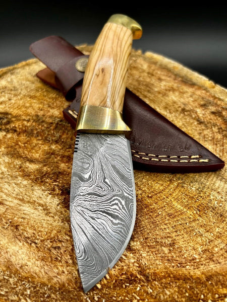 Skinning Blade Damascus steel knife with olivewood handle and brass bolsters.
