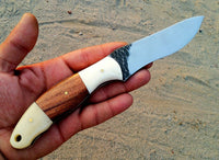 "Detail of the stone texture hand-forged blade of the hunting knife."





