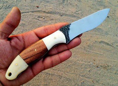 "Detail of the stone texture hand-forged blade of the hunting knife."





