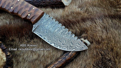 Detail view of the full tang Damascus steel blade of the great skinning knife, emphasizing its sharpness and craftsmanship.