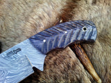 Close-up of the 4.25-inch Damascus steel blade with intricate patterns on a field dressing knife.
