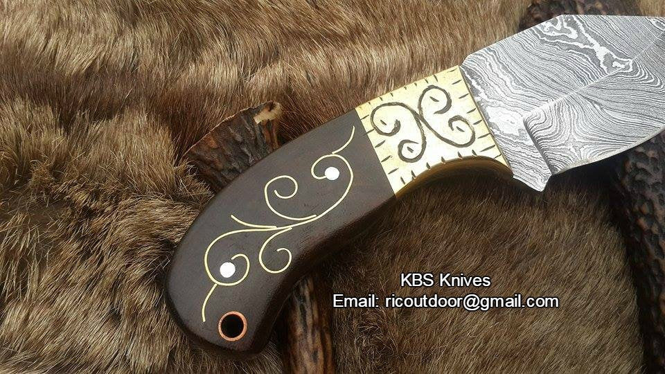 Close-up of the 2.75-inch Damascus steel blade with intricate patterns.