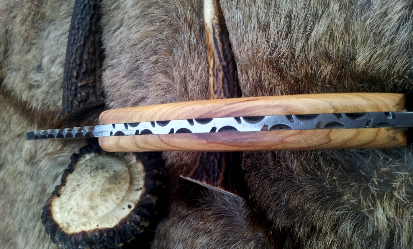 Olive wood handle of the gut hook knife, highlighting its comfort and grip.
