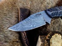 Exotic Pakka wood handle with ergonomic grip on a custom Damascus steel skinning knife.
