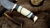 Handmade Damascus hunting knife with protective leather sheath for secure transport





