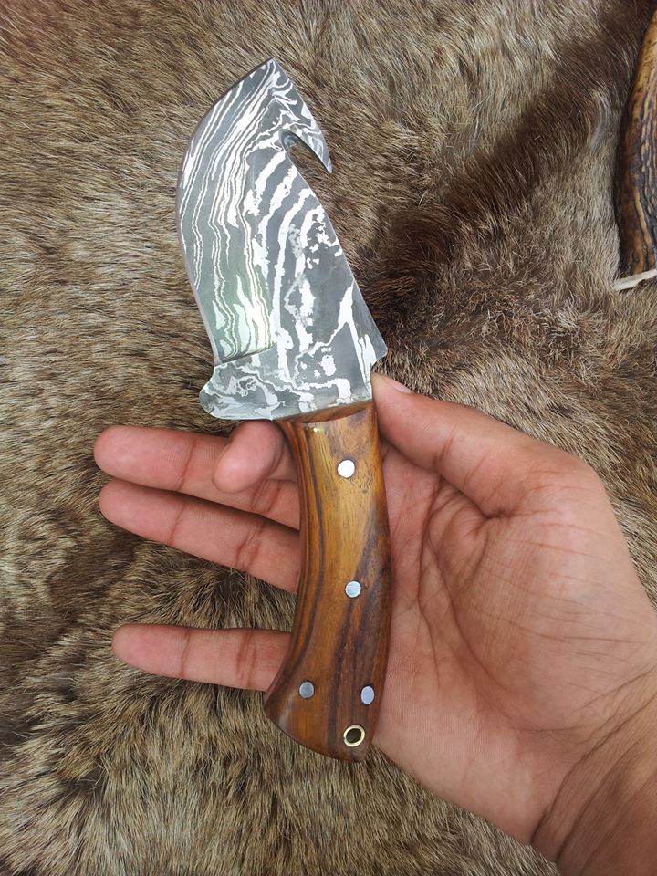 Custom handmade Guthook knife with rosewood handle on display

