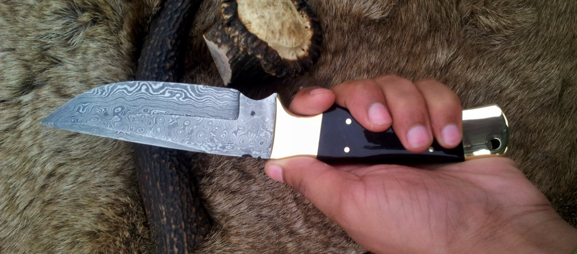 Close-up of raindrops Damascus steel blade on KBS Knives fixed-blade hunting knife
