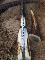Rustic antler horn handle with brass bolster on a Damascus steel skinning knife.
