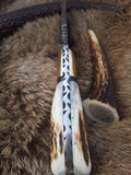 Rustic antler horn handle with brass bolster on a Damascus steel skinning knife.
