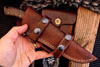"Full view of hunting knife with leather sheath for secure storage."
