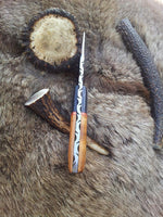 Olivewood handle with exotic pakka wood bolster on a field dressing knife.
