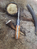 Olivewood handle with exotic pakka wood bolster on a field dressing knife.
