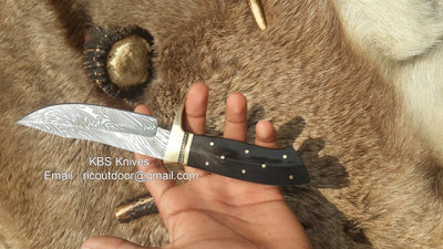 Sharp Damascus Hunting Knife with leather sheath and ergonomic handle.
