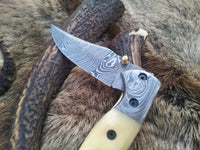 Close-up of bone handle and Damascus bolster on the BoneCraft pocket knife
