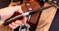 "Close-up of Damascus steel blade on hunting knife, 5-inch length."
