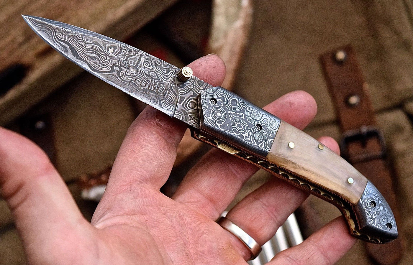 Everyday Carry Damascus Steel Pocket Knife with water buffalo horn handle and Damascus bolsters.