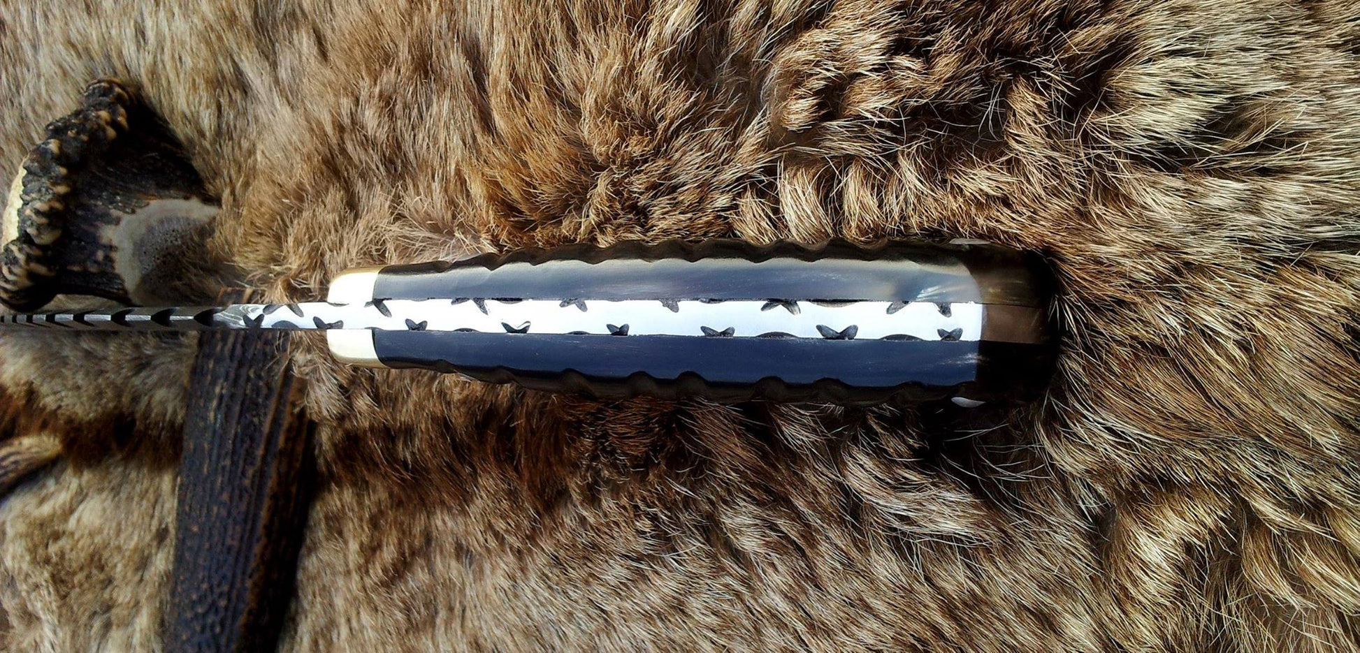 Close-up of Buffalo Horn Handle with Brass Guard on Damascus Steel Gurkha Kukri.
