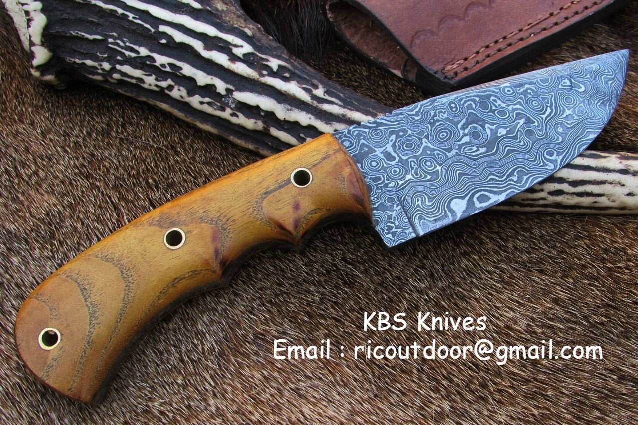 Close-up view of the 4.25-inch Damascus steel blade showcasing intricate patterns.
