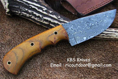 Close-up view of the 4.25-inch Damascus steel blade showcasing intricate patterns.
