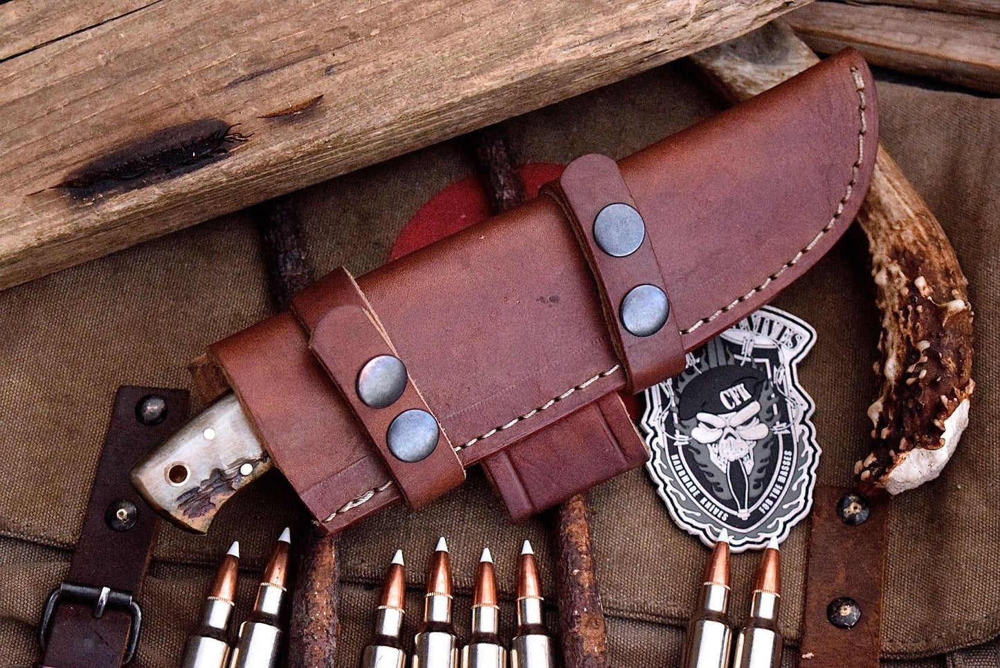 "Deer hunting knife displayed with leather sheath for storage."
