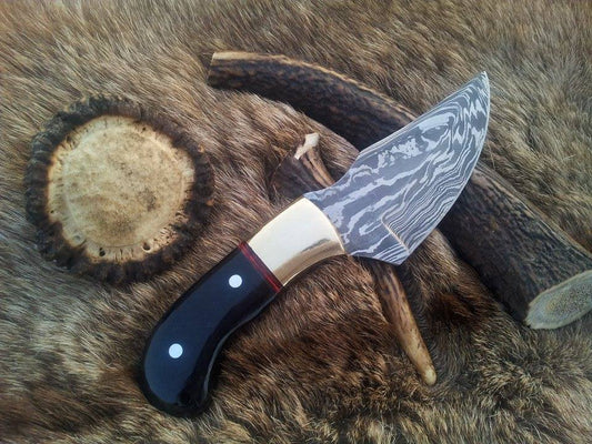 Damascus steel deer skinning knife with a 3.5-inch drop point blade and buffalo horn handle.