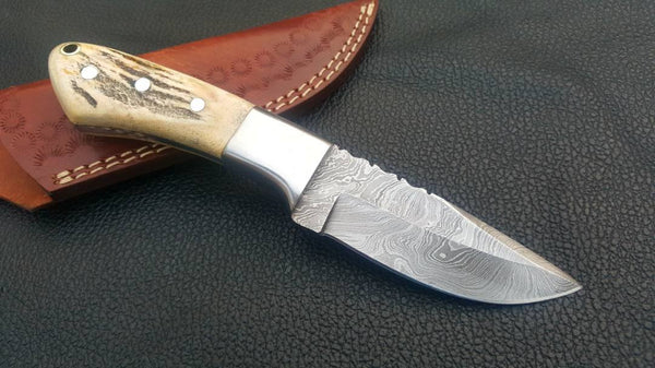 Deer skinning knife with full tang Damascus steel blade and antler horn handle.
