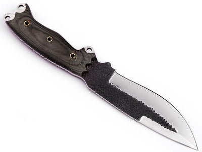 Bushcrafter using camp knife for outdoor survival tasks

