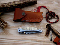 Close-up of the 3-inch Damascus steel blade showcasing razor-sharp edge and intricate file work.