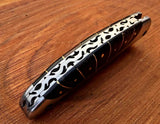 Close-up of the 3-inch Damascus steel blade with razor-sharp edge and intricate file work.