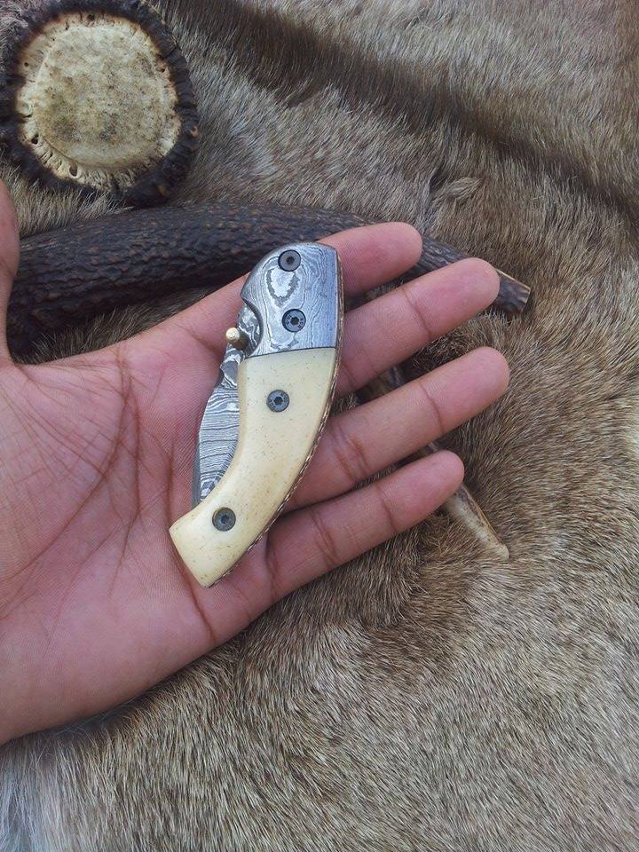 Close-up of the bone handle and Damascus bolster on the folding pocket knife