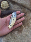 Close-up of the bone handle and Damascus bolster on the folding pocket knife