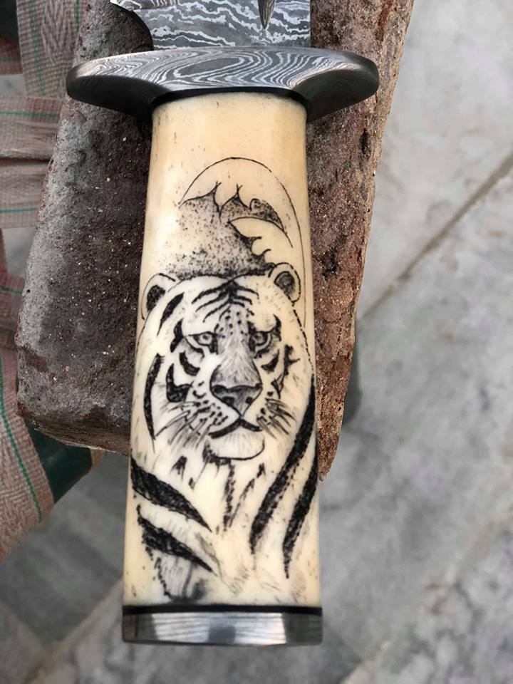 Detailed view of the Damascus steel blade with blood groove on the Hand Engraved Hunting Bowie Knife.